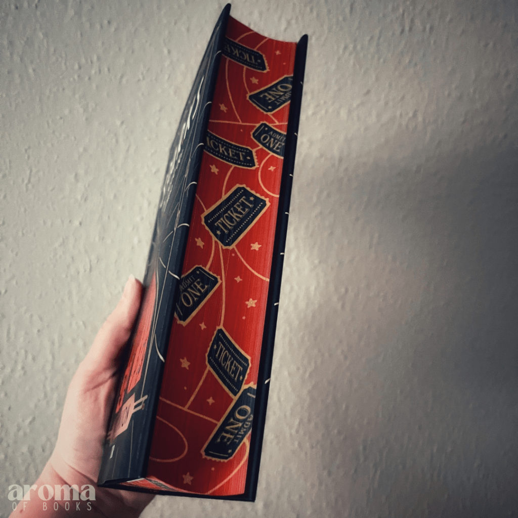 Man sieht den Farbschnitt des Buches, dieser ist in Rot und Gold gehalten und mit Eintrittskarten/Tickets verziert.